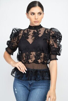 A knit top featuring sheer material, lace trim, short bubble sleeves, a mock neckline, a back keyhole closure, and a smocked waist. Made in China